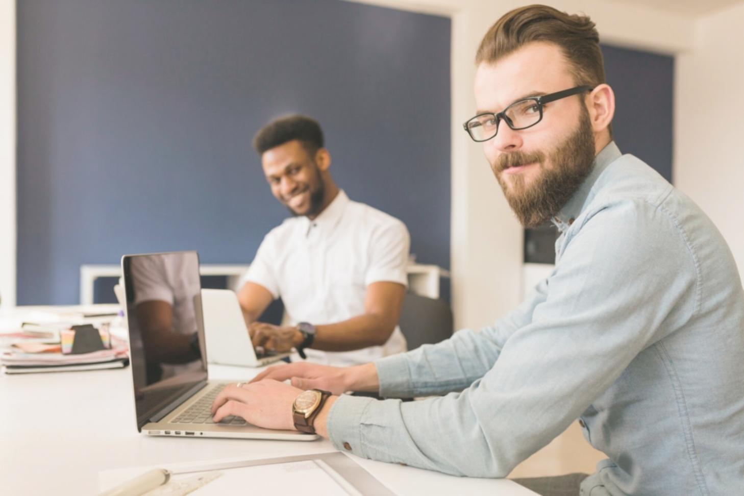 Small group of financial professionals collaborating on valuation projects using modern technology and analytical tools